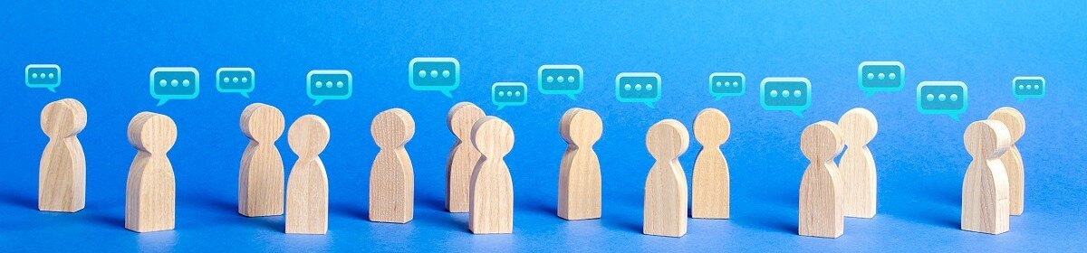 14 wooden dolls representing people with speech bubbles above their heads