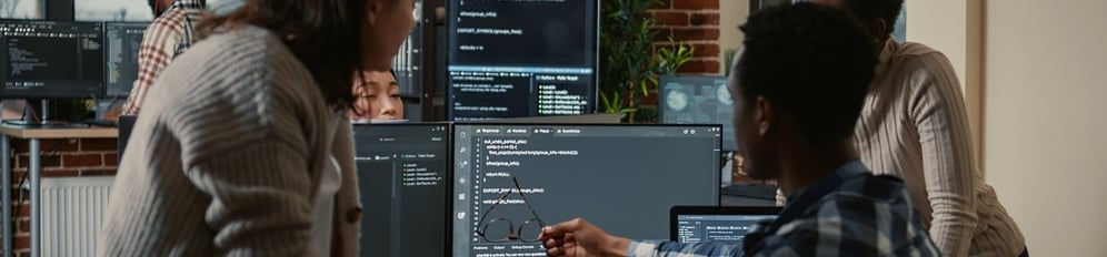 two reserechers looking at a code on a computer screen
